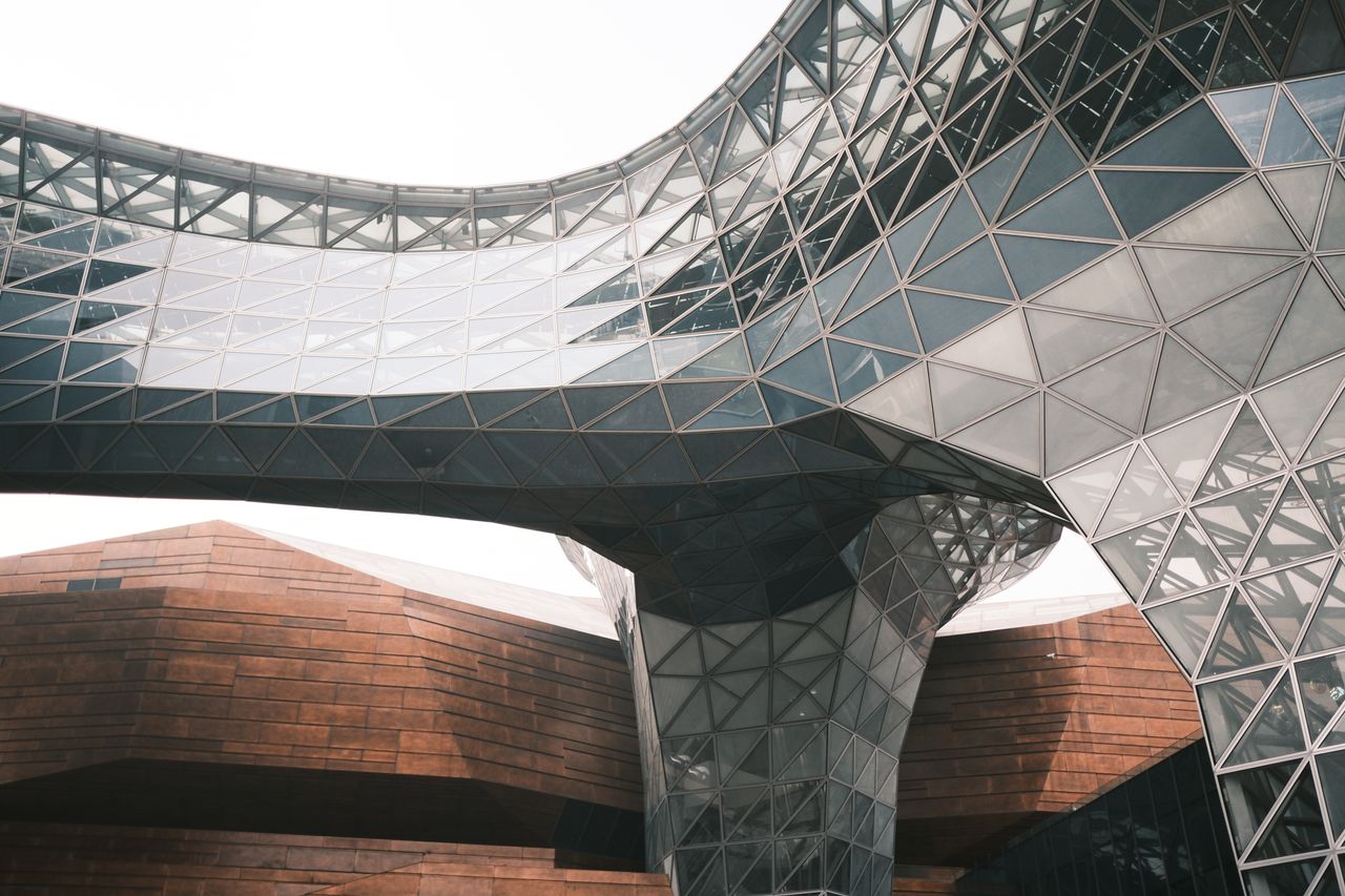services-02 Captured view of the World Expo Museum's glass and steel structure in Shanghai's modern architectural style.