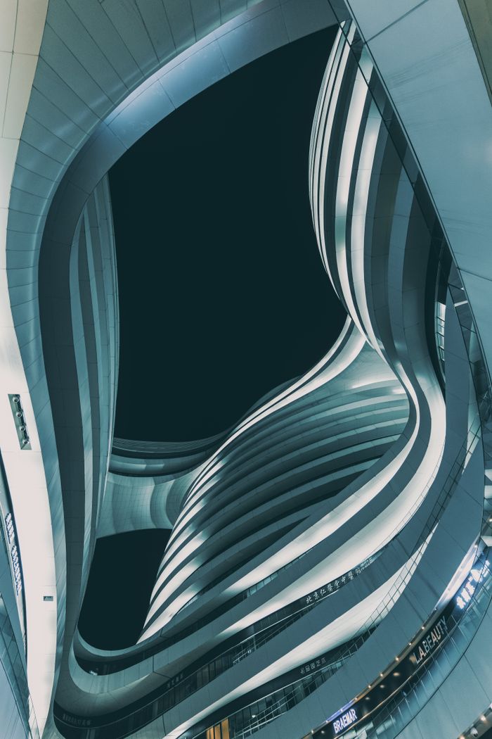 who-we-are Low angle view of modern Milky Way Soho in Beijing at dusk. Futuristic curves and lines in dramatic urban setting.